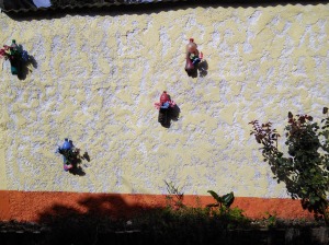 Plastic flowers in plastic bottles on a concrete wall